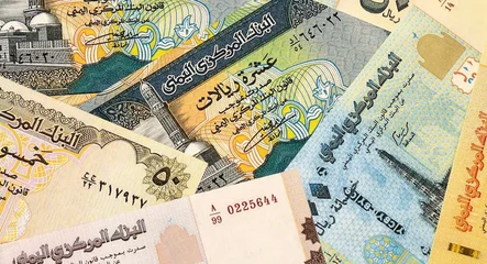 Yemeni rial money bills in pile on table. Yemen YER currency cash close up © Viktor