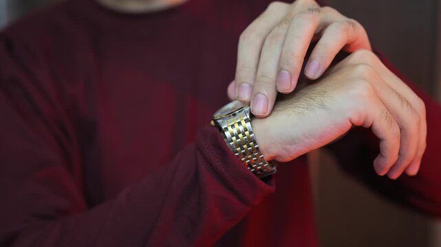 a watch with a snow strap on the hand of a man in brown clothes