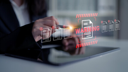 Obraz na płótnie Canvas A business professional reviews critical documents on a tablet, highlighting a warning alert to emphasize the importance of secure data management in a modern workspace. Gantry
