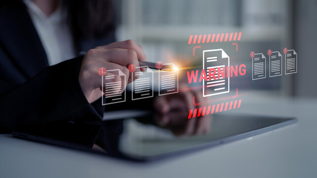A business professional reviews critical documents on a tablet, highlighting a warning alert to emphasize the importance of secure data management in a modern workspace. Gantry