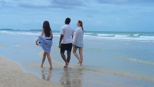 Three diverse friends having an engaging, unplugged conversation, highlighting authentic relationships and mental wellbeing by the sea.