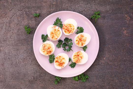 Classic deviled eggs. Top view on a dark stone background.