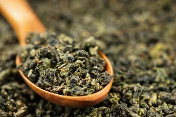 Premium dried oolong tea scoop on minimal solid background © Alexander