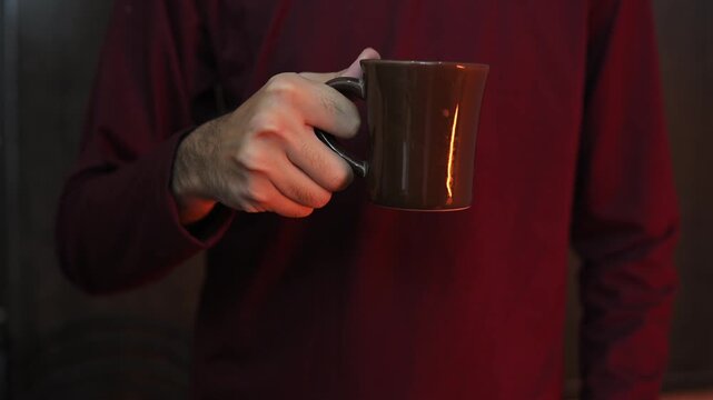 Person Holding Hot Drink Cup During Relaxing Break