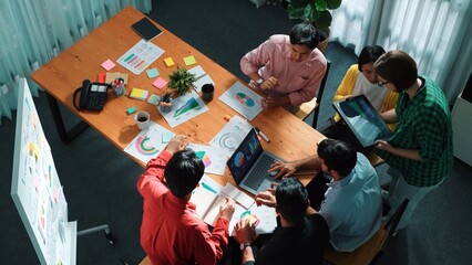 Fototapeta na wymiar Top view of skilled business team discussing and talking about financial statistic to make decision for investment. Creative project manager looking at data analysis from laptop screen. Convocation.