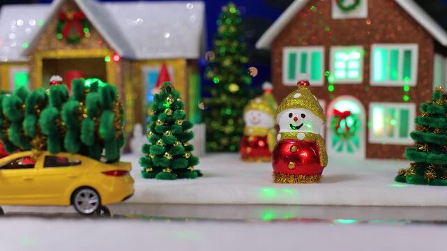 Christmas Miniature Scene with Toy Yellow Car Carrying Trees and Wind-up Santa Claus