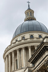 Fototapeta premium Paris, France, magnificent architectural details of the Pantheon dome, its iconic cupola with a cross, classical columns, intricate balustrades, and neoclassical grandeur against a cloudy sky