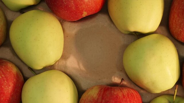 Man picking fresh red apple from center of wooden crate