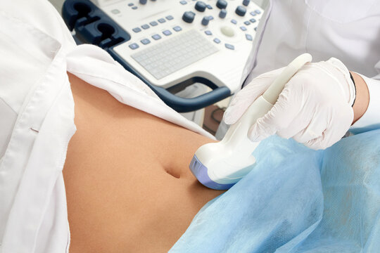 Cropped view of pregnant woman at gynecologist's doing ultrasound scan of the lower part of the belly