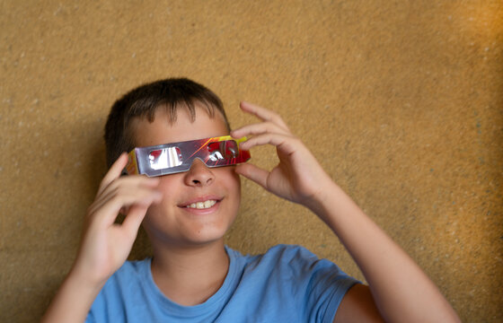 Boy wearing solar eclipse glasses with an expression of curiosity and confidence