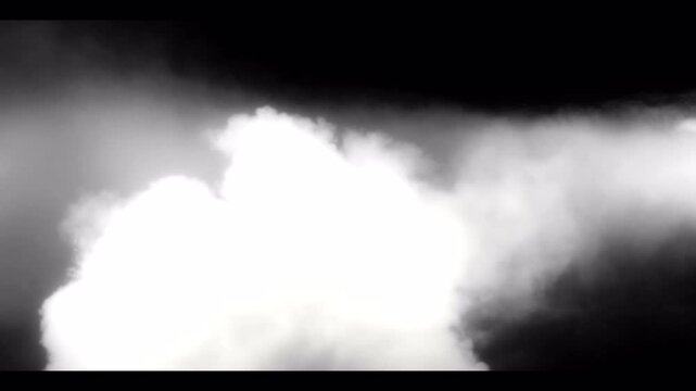 Dense white smoke clouds billowing on black background.