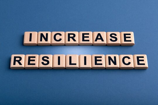 Increase resilience phrase written on wooden letter tiles on a blue background