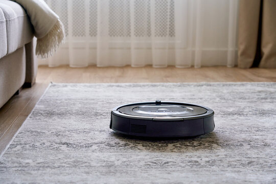 Robotic vacuum cleaner on the floor in cozy modern living room