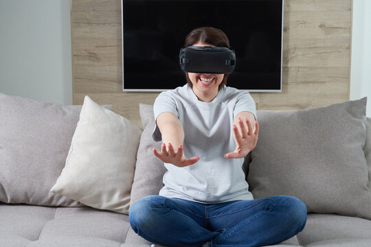 Happy young woman playing on VR glasses indoor, Virtual reality concept with young girl having fun with headset goggles, with copy space