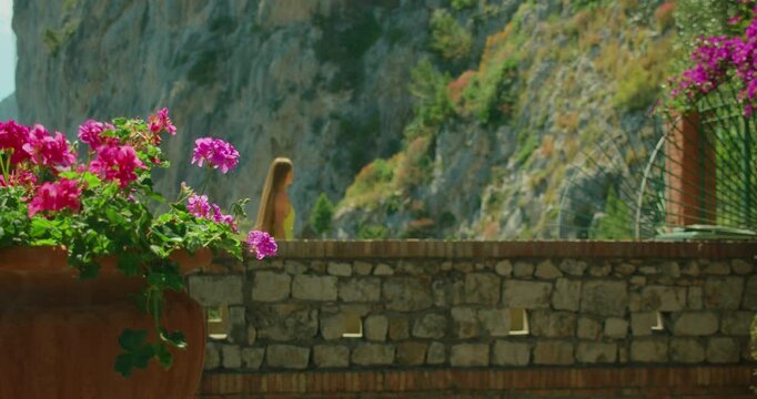 Woman walking at stone bridge near cliffs in Capri Italy enjoying a peaceful summer travel moment