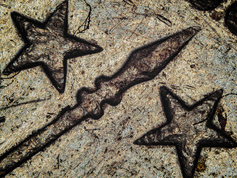 Microscopic view of engraved stars on Swiss franc coin under microscope