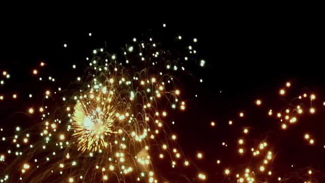 Brilliant fireworks illuminate the night sky during Christmas and New Year celebrations. Golden bursts and shimmering cascades create a festive and jubilant atmosphere, making hearts glow.