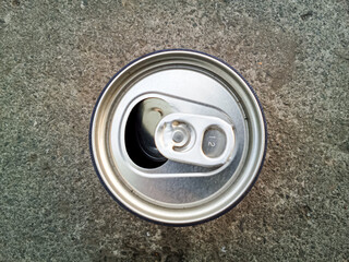 Top down view of an open and empty aluminum drink can discarded on a rough concrete ground. Concept of recycling, littering, or outdoor refreshment. © UtamiNur96