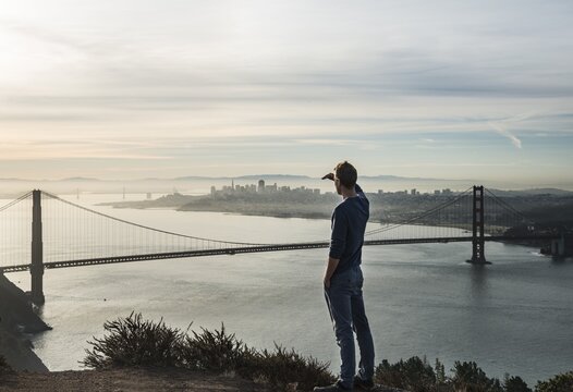 Young man looks to the Golden Gate Bridge, San Francisco, California, USA
