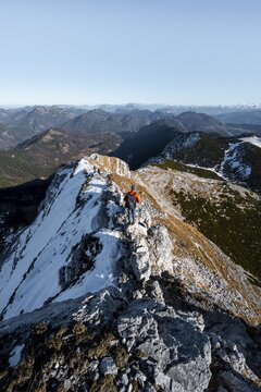 Climbers on the summit ridge with first snow in autumn, hiking trail to Guffert, view of mountain panorama, Brandenberg Alps, Tyrol, Austria