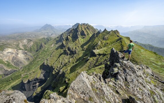 Hikers on rocks, Pointed green mountain peaks on the ridge of Tindfj&ouml;ll, overgrown tuff rocks, wild nature, Icelandic Highlands, &THORN;&oacute;rsm&ouml;rk, Su&eth;urland, Iceland