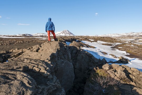 Man stands at Continental Rift between North American and Eurasian Plate, Mid-Atlantic Ridge, Rift Valley, Silfra Rift, Krafla, North Iceland, Iceland