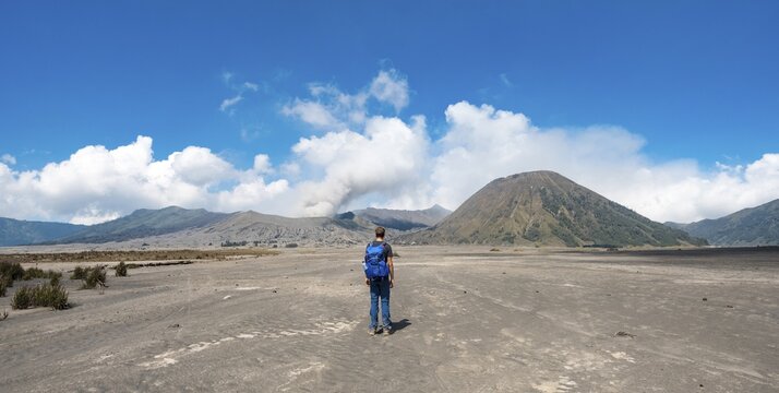 Young man in the caldera on his way to the crater of the Gnung Bromo, smoking volcano Gunung Bromo, Mt. Batok, Mt. Kursi, Mt. Gunung Semeru, Tengger Caldera, National Park Bromo-Tengger-Semeru, Java, Indonesia.