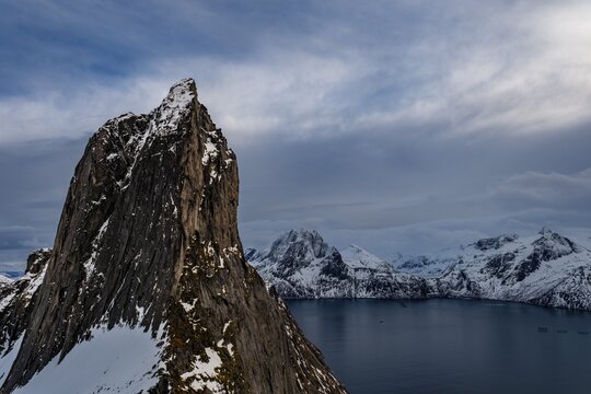 Steep mountain Segla, Mefjorden fjord with snowy mountains, Senja island, Troms, Norway