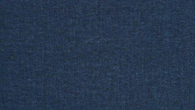 Close up of a dark blue denim fabric texture with a detailed diagonal woven pattern