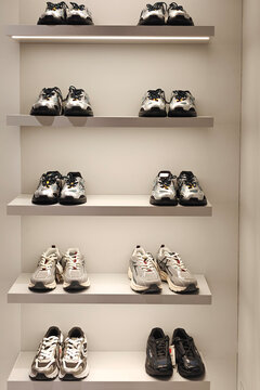 Minimalist sneaker display on retail shelves in modern clothing store