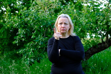 Fototapeta premium A firm gesture, lowered lip corners and knitted brows communicate disapproval and warning. The scene captures a moment of criticism, authority and strong emotional response.