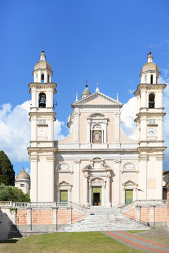 Saint Steven's Basilica (Basilica di San Stefano) in Lavagna, Italy, on a bright spring afternoon with blue sky and some white fluffy cumulus clouds