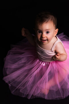 Happy baby girl wearing pink tutu looking up