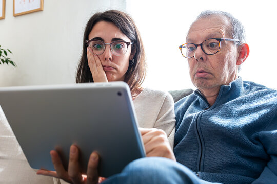People reacting with shock and disbelief watching digital content on tablet