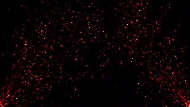 Fiery glowing embers and orange sparks rising against a dark black background fire floating particles heat hot