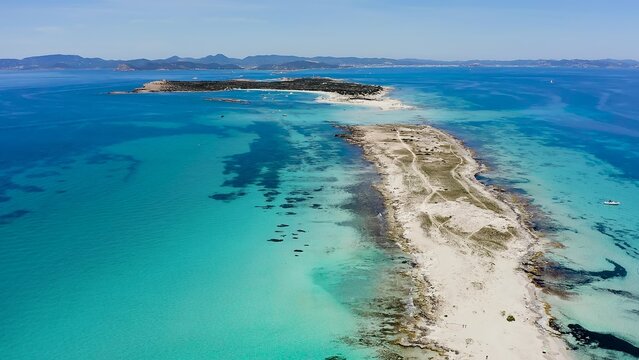 Aerial view looking north of Ses Illetes beach on the island of Formentera, with the horseshoe-shaped island of Espalmador in the background, Spain. 