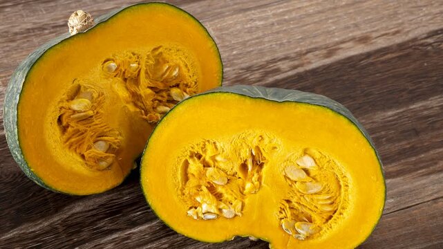 Fresh Pumpkin squash cut in half with visible seeds and golden-orange flesh
