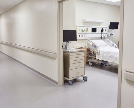 Clean hospital ward corridor with patient room entrances and clinical equipment - clean clinical interior