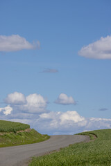 Obraz premium Dirt road going up a hill into blue sky