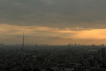 Fototapeta premium 雨雲の隙間から差し込む夕陽と天使の梯子 都市風景 / Sunbeams and Crepuscular Rays Shining Through Rain Clouds City Landscapes