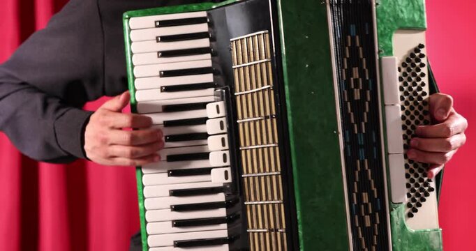 Man playing piano accordion on stage, closeup