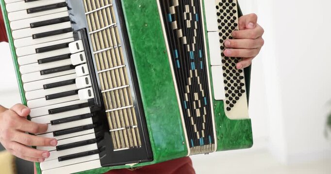 Man playing piano accordion at home, closeup