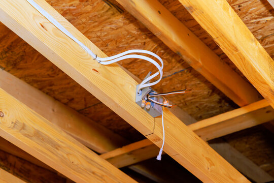 Wiring setup in building renovation project under wooden beams in construction area