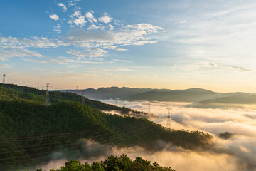 Sunrise over misty green hills and forested mountain valley © Zhaochen