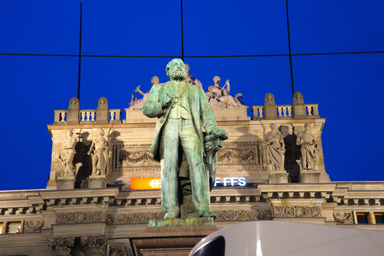 Cityscape at railway station town square with Alfred Escher bronze statue at Swiss city of Z&uuml;rich on an autumn evening. Photo taken December 13th, 2025, Zurich, Switzerland.