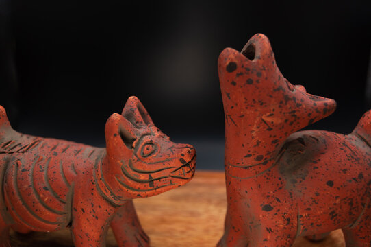 Pre-Columbian clay sculpture of a Xoloitzcuintle dog from Colima, Mexico, with a wooden base. Ancient archaeological figure of a Mexican dog. Sculpture for a Day of the Dead offering.