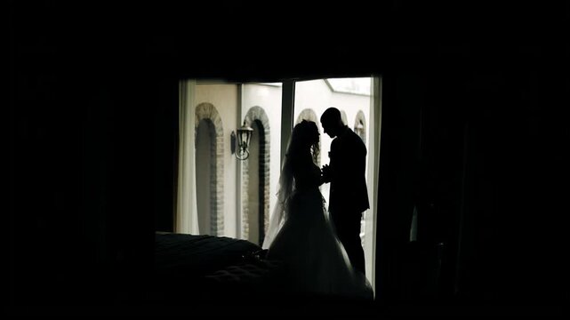 Silhouettes of a guy and a girl in love. Their heads touch.