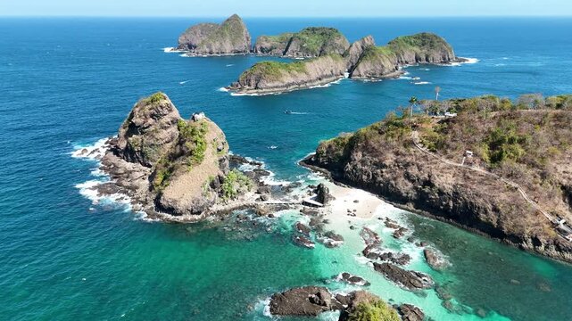 Stunning aerial footage of steep rocky cliffs and tropical islets surrounded by crystal-clear turquoise ocean waters