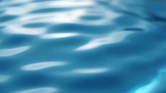 Smooth blue water with shimmering ripples and soft reflections, evoking tranquil ocean light at dawn
