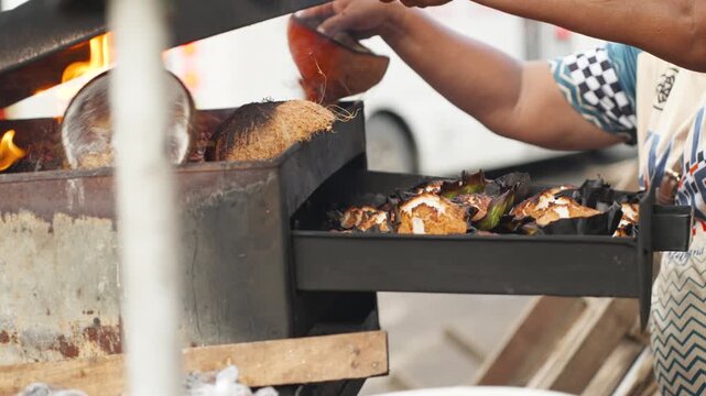 Street Food Vendor Cooking Traditional Bibingka Rice Cake Using Dried Coconut Shells as Fuel